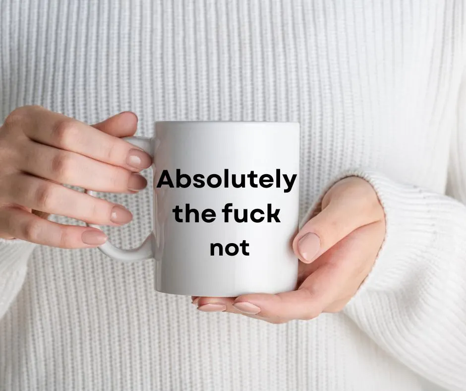 White mug with text 'Absolutely the fuck not' held by hands against a white sweater background