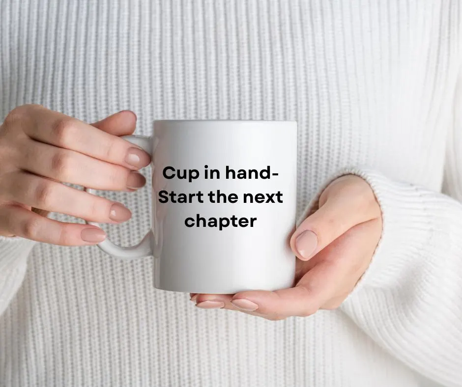 White mug held by hands with text 'Cup in hand- Start the next chapter' with a white sweater background
