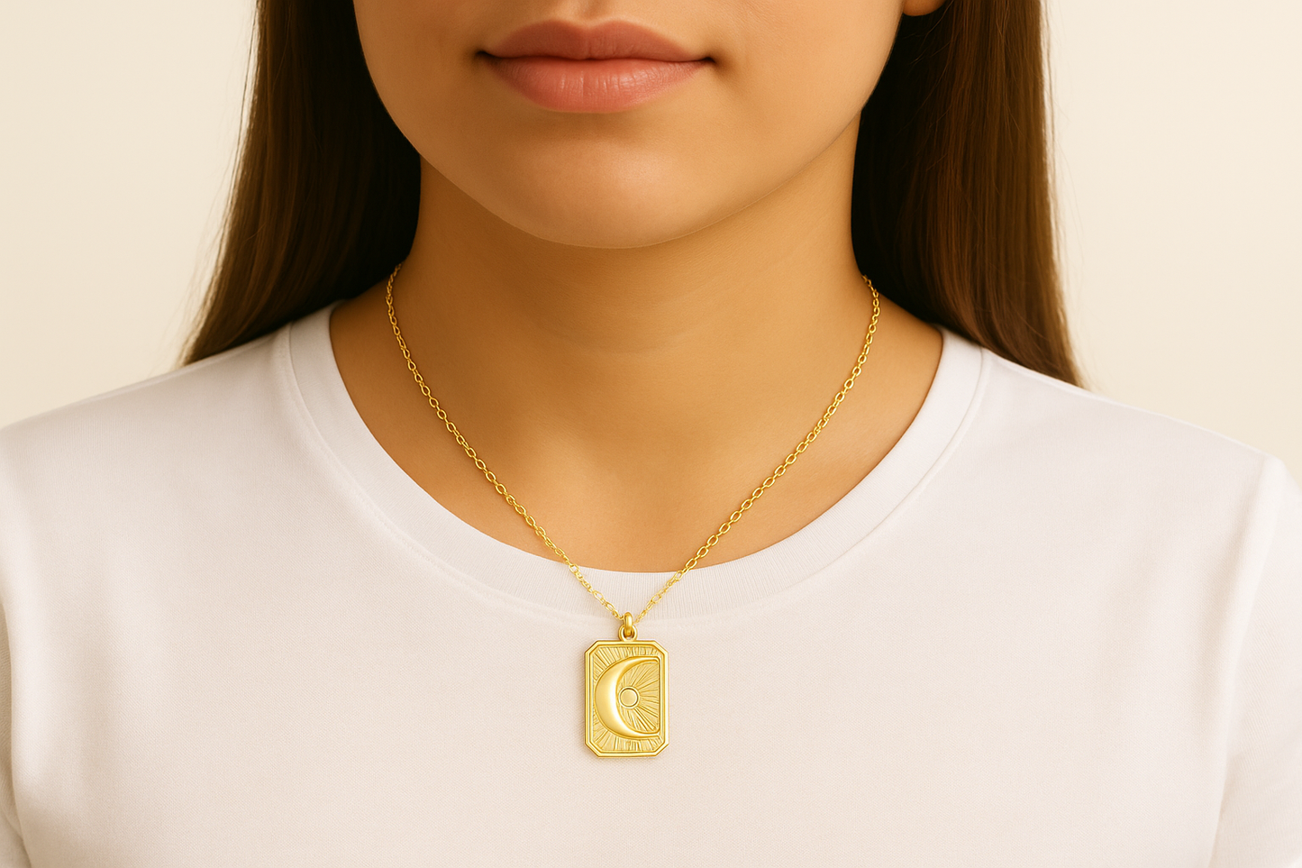 Person wearing a gold moon necklace on a plain background