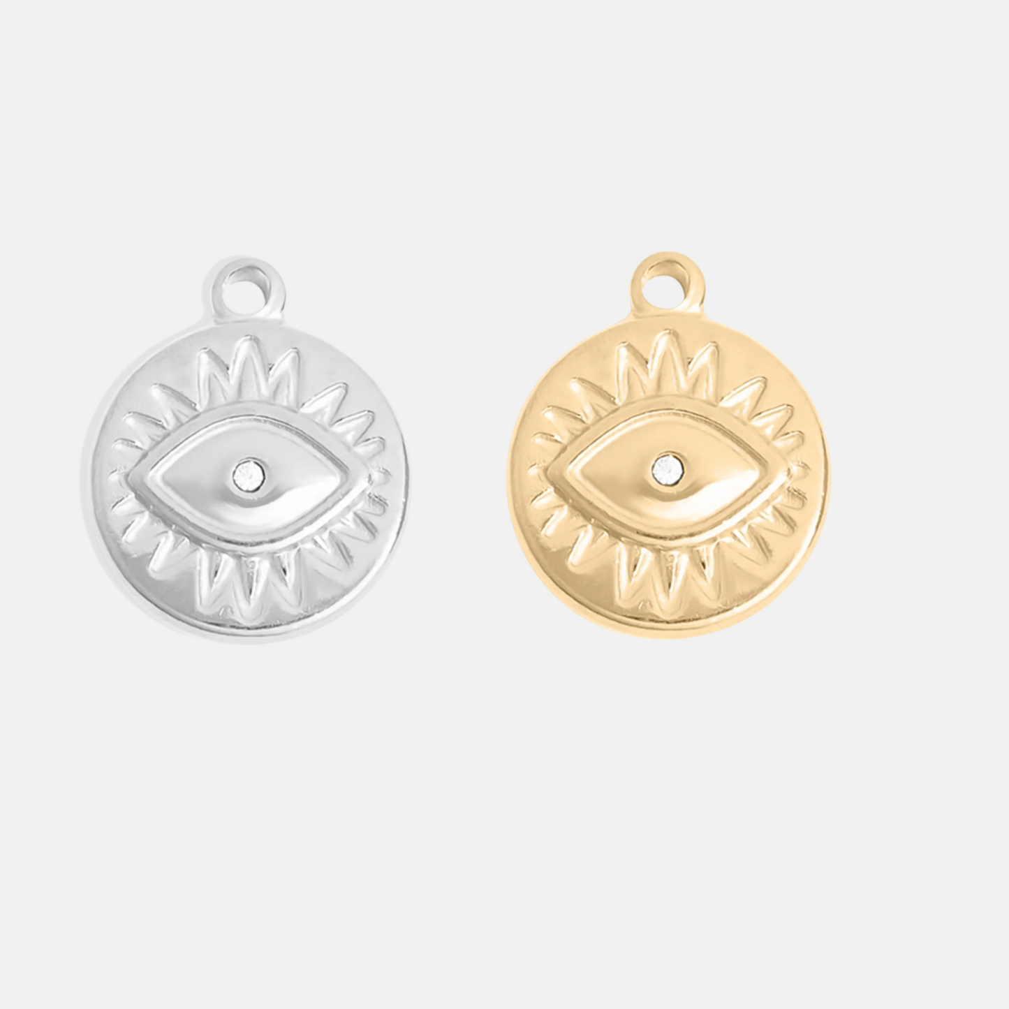 Gold and silver evil eye pendants on a white background