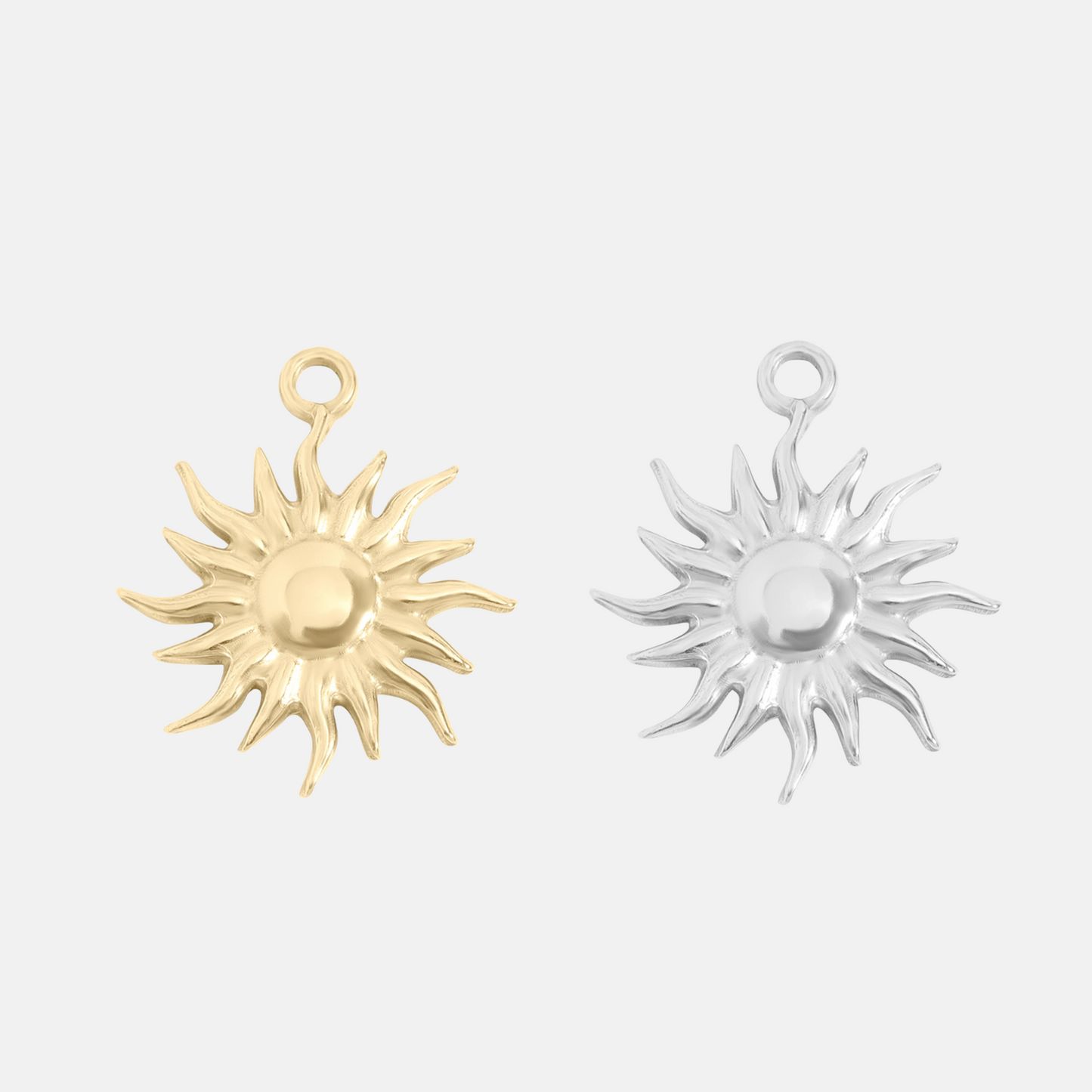 Gold and silver sun-shaped jewelry pendants on a light gray background