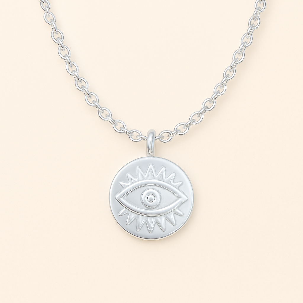 Silver necklace with an evil eye pendant on a light beige background