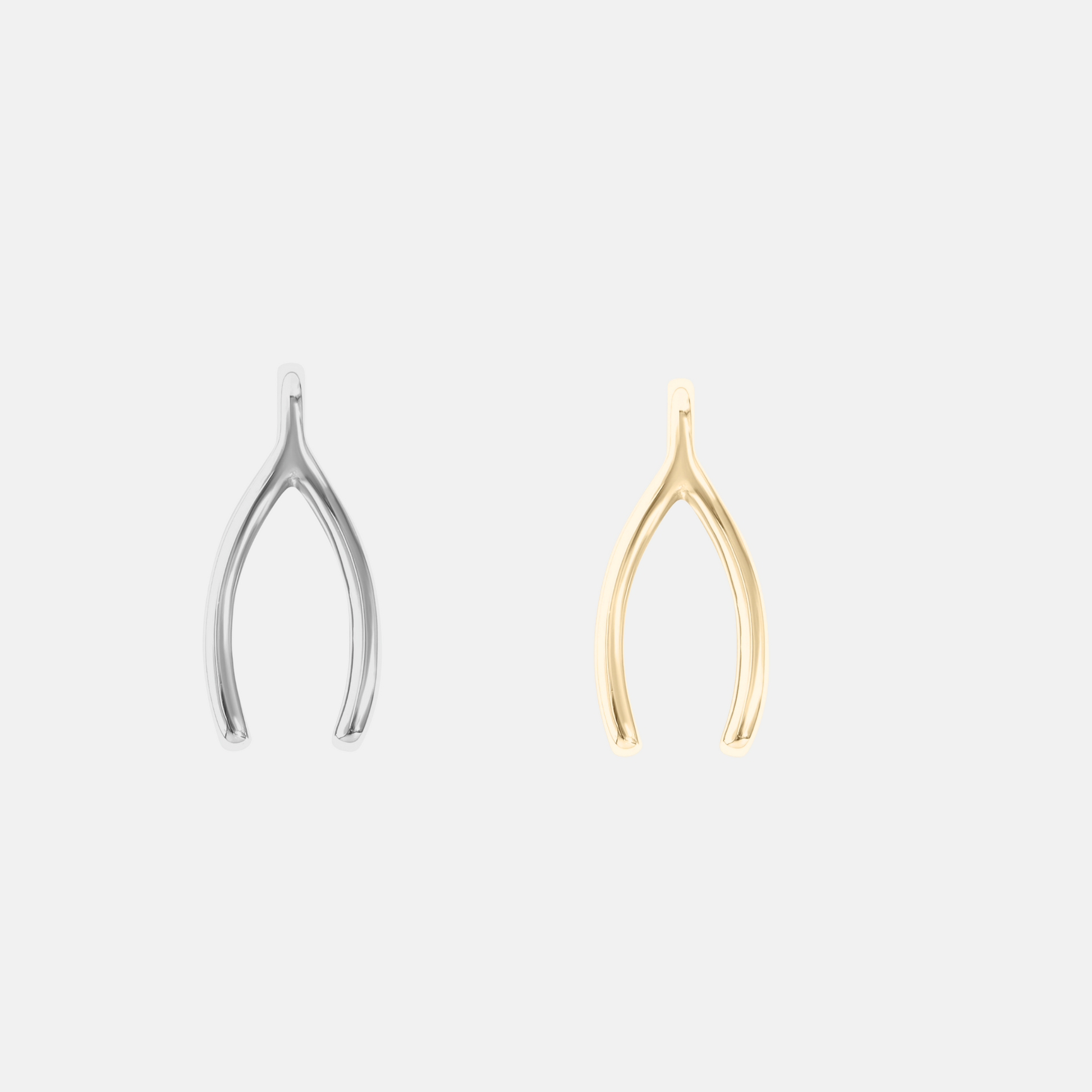 Silver and gold wishbone-shaped charms on a light gray background