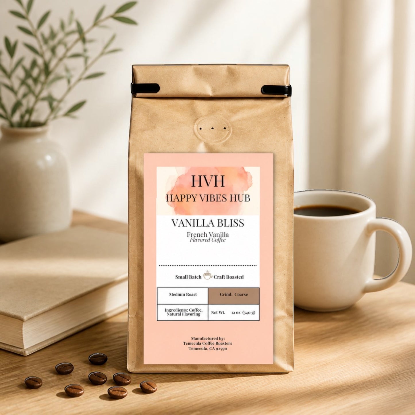 Happy Vibes Hub compostable kraft bag of Vanilla Bliss coffee beans on a wooden table with a cup of coffee and book