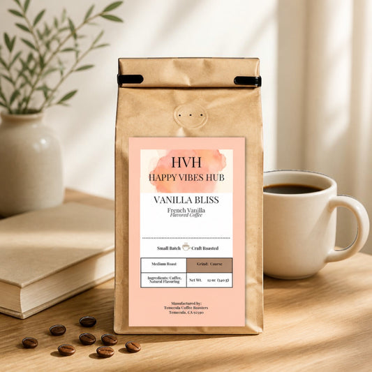 Happy Vibes Hub compostable kraft bag of Vanilla Bliss coffee beans on a wooden table with a cup of coffee and book